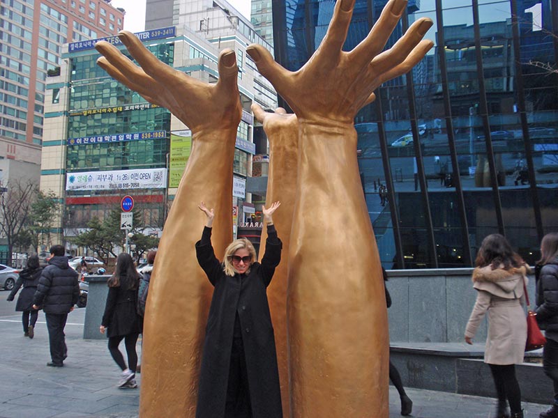 Catherine Heald raises her hands in Seoul