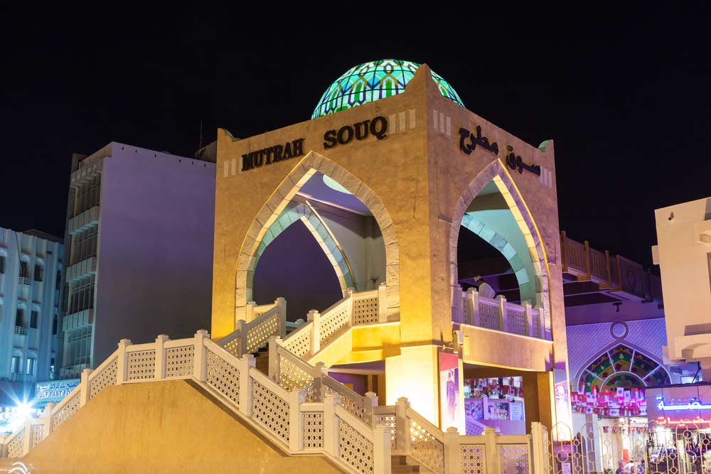 Muttrah souq entrance illuminated at night.